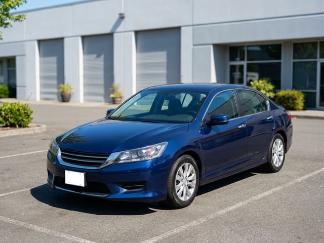 Example loaner car: a blue midsize sedan parked outside an auto body shop